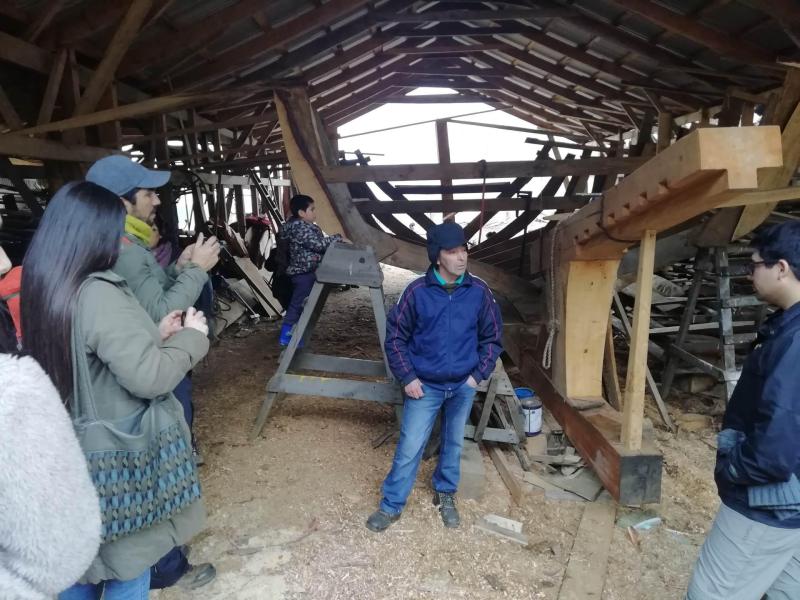 Don Benito Villlanueva contando sobre su oficio al interior del astillero de Cutipay, en el marco de la visita de integrantes de talleres de SUBPO, pertenecientes a comunidades indígenas de la costa de Corral. (Día del Patrimonio Cultural, 2019)