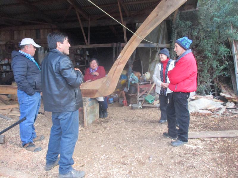 Don Ernesto Villanueva conversa con integrantes del taller de artesanía en maderas muertas, provenientes de comunidades indígenas de Corral, en el marco de la visita gestionada por SUBPO (DPC 2019)