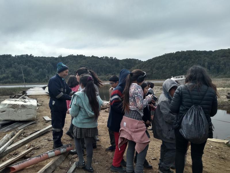 Despedida de sesión en terreno de laboratorio creativo gestionado por CeCrea Valdivia. Los niños se despiden de los carpinteros, luego de haberlos entrevistado y conocido el astillero y su entorno. (Octubre 2019)