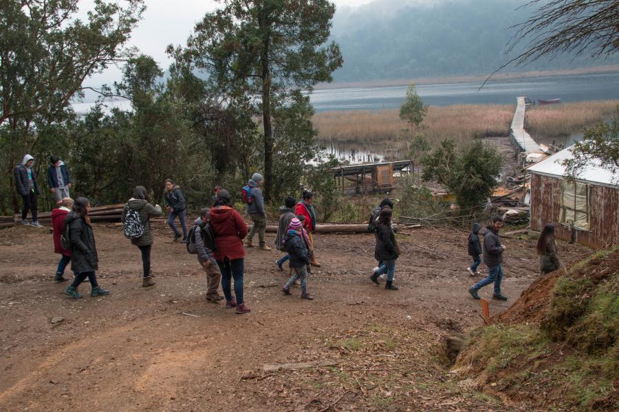 La delegación de escolares de la localidad rural de Pishuinco, organizada por CeCrea bajando hacia el astillero de Cutipay, al fondo se observa el muelle que se interna en el río.